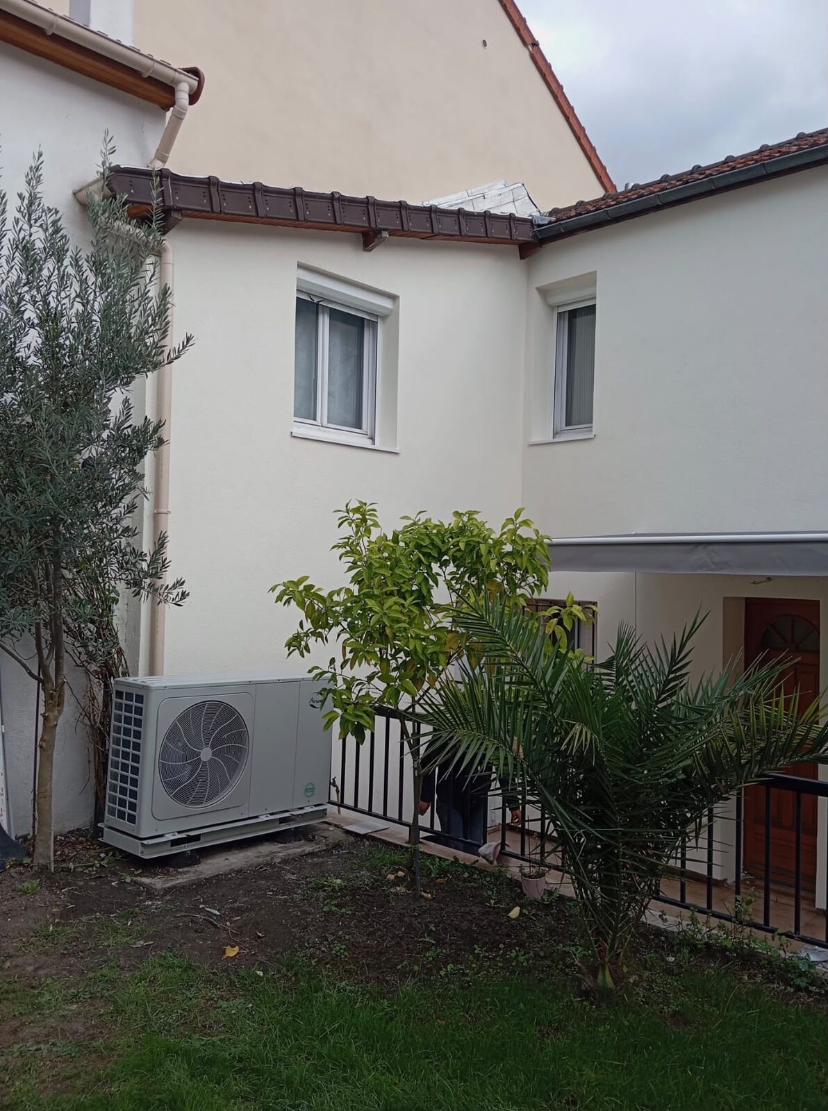 Groupe extérieur Airwell installé dans le jardin d'une maison