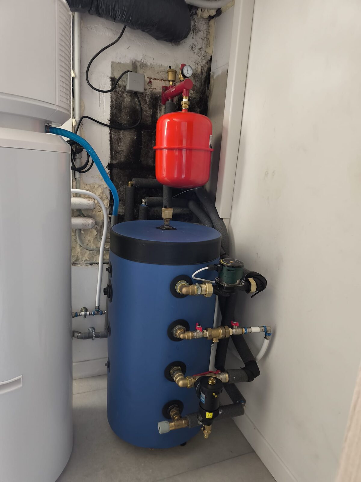 Ballon tampon bleu avec vase d'expansion et raccordement hydraulique soigné