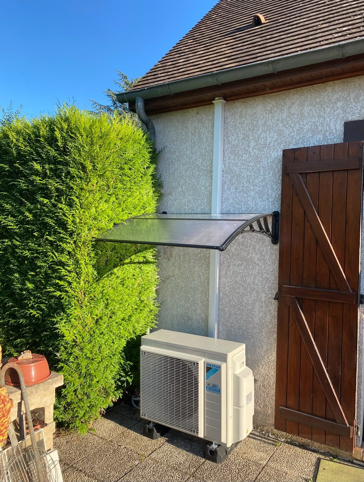 Groupe extérieur Daikin Multi-Inverter protégé sous un auvent contre la façade d'une maison