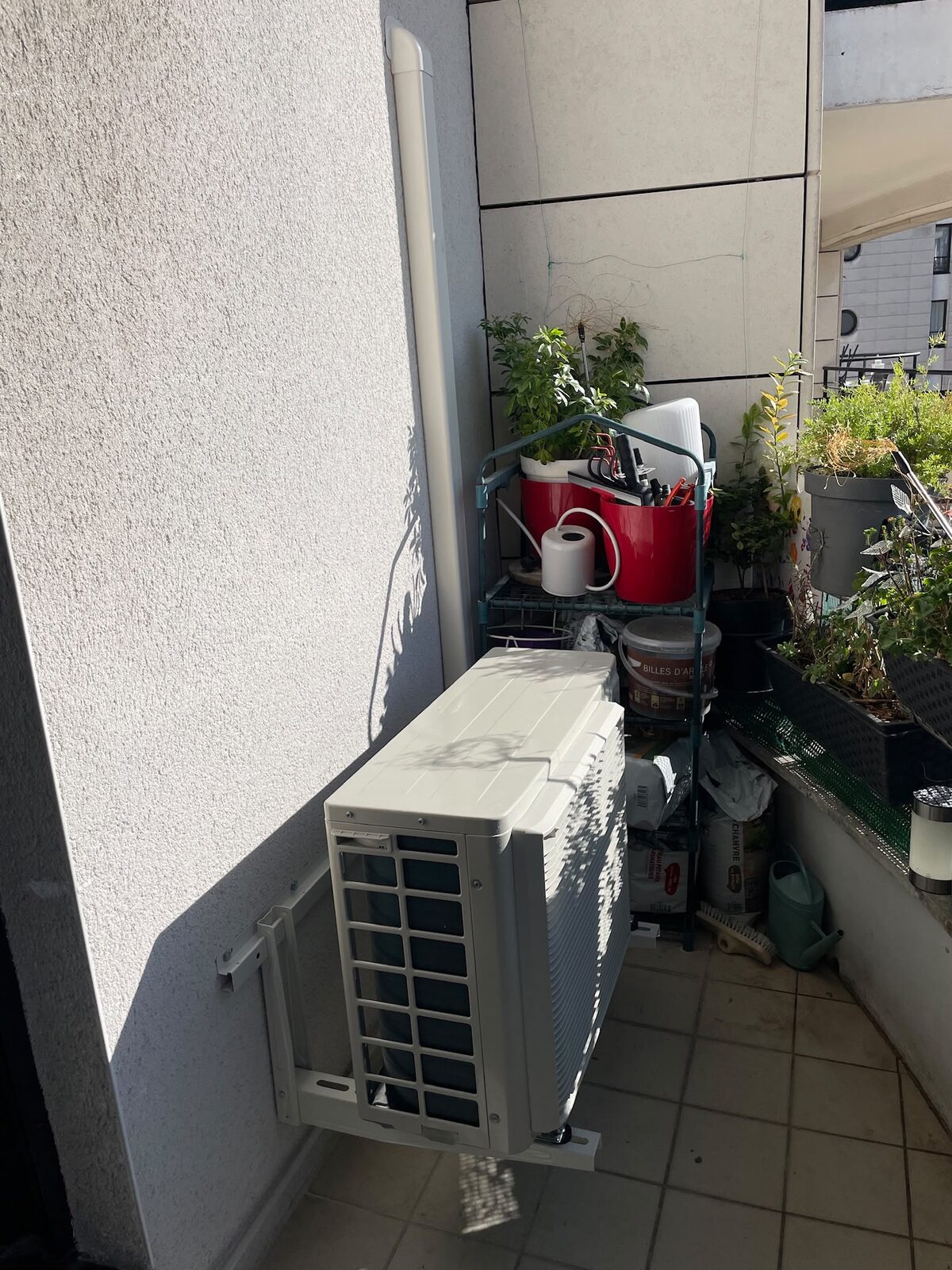 Groupe extérieur fixé sur support mural sur un balcon d'appartement